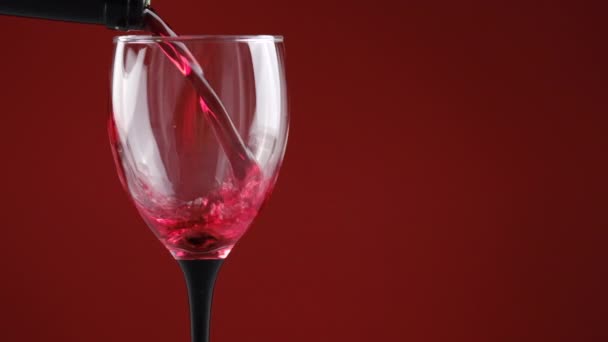 어두운 배경에 병에서 적포도주와 유리를 채우기의 클로즈업 천천히 움직여 와인을 — 비디오