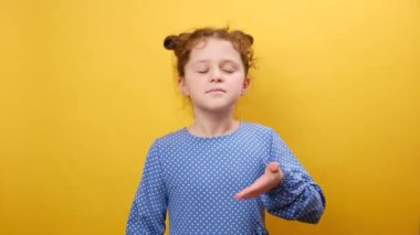 Mutlu küçük kız portresi rahatlatıcı, gülümseyen küçük çocuk gözleri kapalı huzurlu bir nefes al hoş bir koku, sarı arka plan duvarında izole edilmiş bir poz.