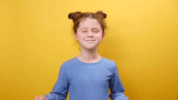 幸運のためのサイン 愛らしい幸せな少女の子供の肖像画は指を交差させ 大切な願いを作り カメラに微笑み スタジオの黄色の背景の壁の上に隔離されました ドリームコンセプト — ストック動画