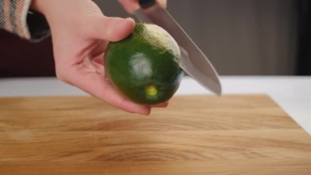 Close Van Vrouwelijke Handen Snijden Avocado Met Keukenmes Verse Rijpe — Stockvideo