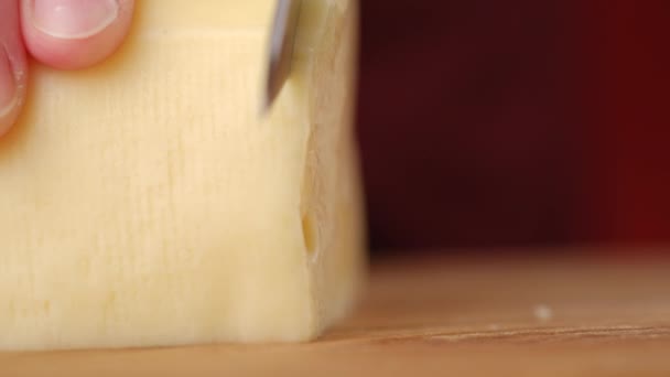 ランチタイムのサンドイッチの準備のために自宅でスライスされたチーズのクローズアップ 未知の若い女性は木製板にナイフでチーズを切断する — ストック動画