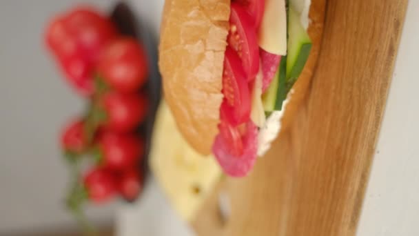 Vertikal Video Baguette Smörgåsar Med Salami Gurka Ost Och Tomater — Stockvideo
