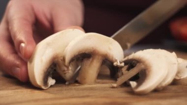 Şampiyon mantarları tahta tahtada bıçakla kesen kadına yaklaş. Lezzetli yemekler için malzemeleri doğramak. Restoran mutfağı. Ağır çekim. Diyet sağlıklı yaşam tarzı konsepti