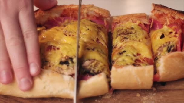 用菜刀在烤面包上切热三明治 用腊米 西红柿和奶酪在木板上切的年轻女子近身 慢动作 — 图库视频影像