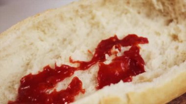 Kadın elinin ahşap tahtada ekmek teknesine domates sosu sürmesi, iştah açıcı vejetaryen yemek konsepti. Yavaş çekim