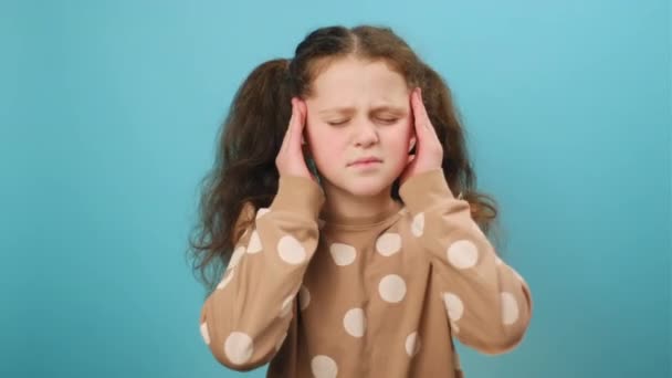 少女因疼痛而头痛 按摩庙宇 鬼鬼祟祟的画像 在工作室的蓝色背景墙上被隔离 儿童与健康问题概念 — 图库视频影像