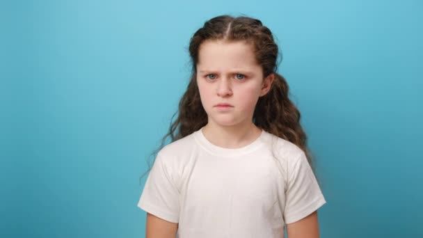 小女孩屏住呼吸 捏住鼻子 对难闻 难以忍受的气味表示厌恶 穿着白色T恤衫 在工作室的浅蓝色背景墙上摆出孤立的姿势的画像 — 图库视频影像