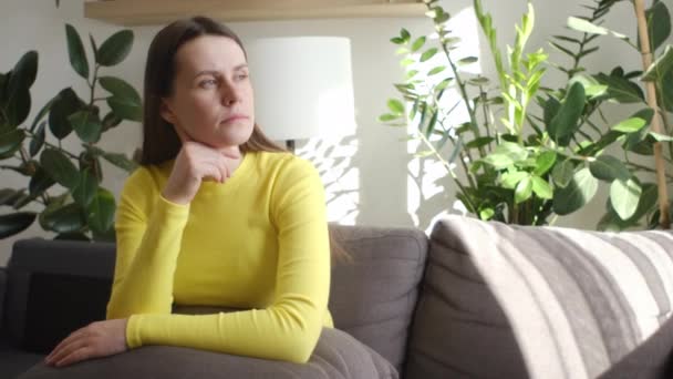 Mujer Joven Triste Sentada Sofá Casa Mirar Distancia Añoranza Luto — Vídeo de stock
