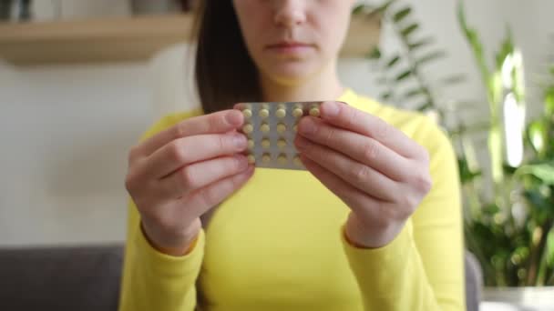 ホルモン経口避妊薬を保持する若い女性の手の選択的な焦点 安全なウイルス性疾患 月経コンセプト 出産管理薬に薬を服用する — ストック動画