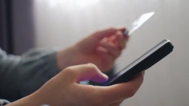 Kredi kartı ve akıllı telefonu tutan kadınların ellerini kapat, bilinmeyen bir kadın online ödeme yapıyor, bankacılık hizmetini kullanıyor, bilgi giriyor, güvenli ödeme yapıyor, alışveriş yapıyor, internet mağazasından sipariş veriyor.