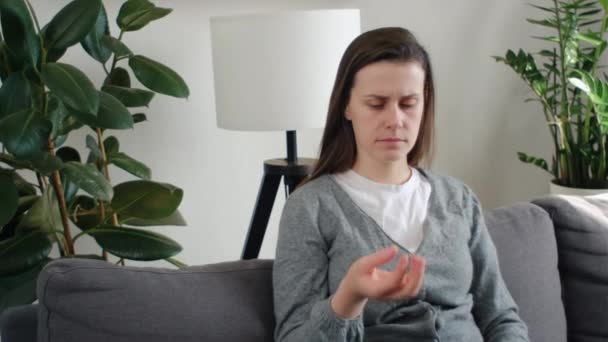 Üzgün Genç Bir Kadın Elinde Alyans Koltukta Tek Başına Oturuyor — Stok video