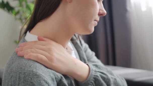 近心烦意乱的年轻高加索女人按摩揉搓僵硬的酸痛肩膀紧张的肌肉疲乏 感到关节背痛 独自坐在沙发上 纤维肌痛的概念 — 图库视频影像