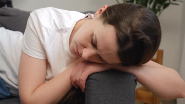 忧心忡忡的年轻女子躺在家里的沙发上 望着别处 陷入深深的哀伤中 感到精疲力尽 — 图库视频影像