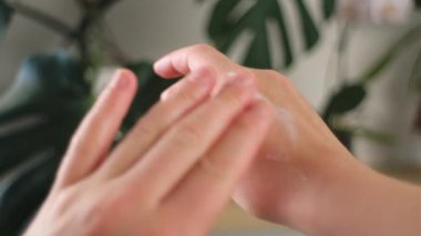 Bilinmeyen genç bir kadının ellerine nemlendirici krem sürmesine yakın çekim. Milenyum kızı günlük vücut bakımı için güneş kremi sürüyor. Kadın derisi konsepti