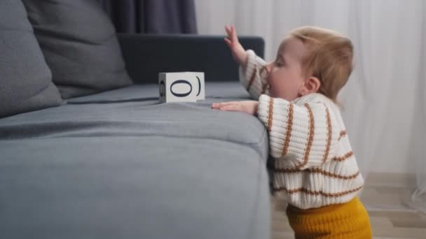 在客厅沙发附近温暖的地板上 抱着一个可爱 嬉闹的幼儿在玩白色的木制立方体玩具 周末休闲活动概念 — 图库视频影像
