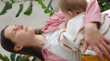 Mutlu, genç bir annenin emzirmekten, annelikten ve tatlı oğluyla duygusal bağ kurmaktan hoşlandığı dikey görüntüler. Aç bebek annesinin yüzüne dokunuyor, annesinin memesinden süt içiyor.