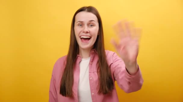 ハローコンセプト スタジオの平らな黄色の背景の壁の上に隔離された魅力的な友好的な幸せな若い女性の肖像画 魅惑的な笑顔のカメラを見て — ストック動画