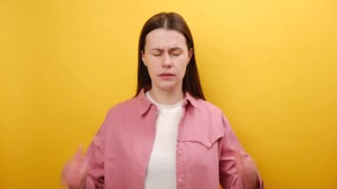 25 yaşında, migrenden muzdarip, kafası dokunmuş, hayır diyen, sorun yaşayan, rahatsızlık duyan, sarı arka plan duvarında izole edilmiş, üzgün, genç beyaz bir kadının portresi.