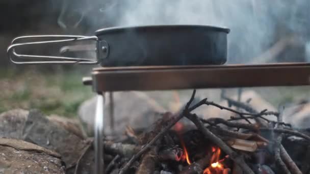 在户外的树林里准备烹调 傍晚时分 在春天森林的篝火上关上锅子 露营旅行 篝火的地方 野生探险中的生存 — 图库视频影像