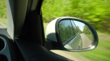 Ilık güneşli bir günde, uzak bir seyahat noktasında bahar ya da yaz aylarında araba sürüşünün yansıması. Güzel seyahat tutkusu ilham ve macera konsepti