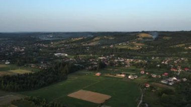 Yaz günü gün batımında kırsal alanda drone görüntüsü. Doğa ilhamı. Huzuru sağlıyorum. Arkaplan dağları üzerinde küçük binaları olan kırsal alan. Turizm ve seyahat tutkusu için durak