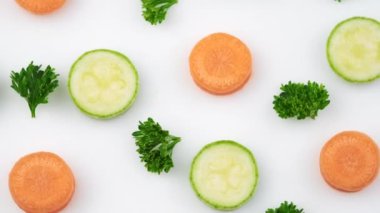 Stüdyoda beyaz arka planda izole edilmiş taze sebzelerin üst görüntüsü. Sebze salatası, kabak ya da ilik, havuç ve maydanoz için ham malzeme. Düz yatıyordu. Yiyecek konsepti