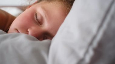 Beyaz, şirin bir kızın portresini yakından çek. Onun beşiğinde tatlı tatlı uyuyor. Yatak odasında uyurken renkli rüyalar görüyor. Tasasız çocukluk konsepti