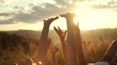 Arka plandaki dağlarda kolları havada çimlerin üzerinde uzanan çocukları hayal etmek. Gün batımında genç kızlar el kaldırıyor. Çocuklar doğada dinleniyor. Özgürlük duygusu ve uçma düşüncesi