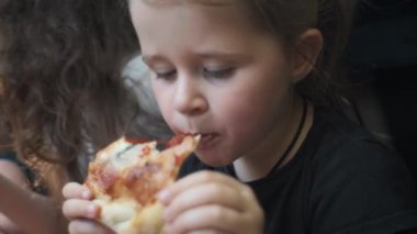 Şirin küçük kız ve erkek kardeşlerin açık bir arabanın bagajında oturup yaz mevsiminde taze pizza yemesi. Mutlu çocukluk, fast food yemek, ya da otomobil yolculuğu öğle yemeği tatili konsepti