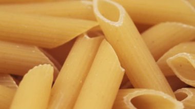 Çiğ makarnayı daire şeklinde döndür. Makarna. Geleneksel İtalyan mutfağı konsepti. Durum buğdaylı makarna. Gıda arkaplanı