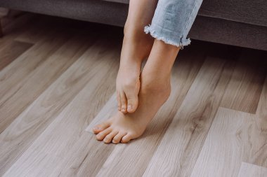 Genç bir kadın ayaklarını kaşındırıyor, ayağını kaşındırıyor, cildinde sorun var, mantar iltihabı, mantar enfeksiyonu, alerjik reaksiyon, egzama. Ayak ağrısı kavramı