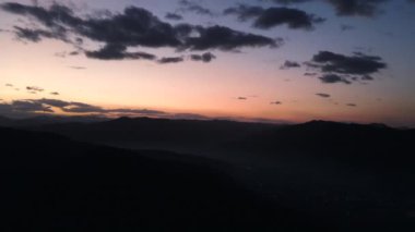 Siluet dağlarının ve gece gökyüzünün inanılmaz renkli bulutlu görüntülerinin hava aracı görüntüleri. Gezgin şehvet, büyüleyici ve doğa. Arka planda sıradağlar var. Temiz ve huzurlu bir manzara