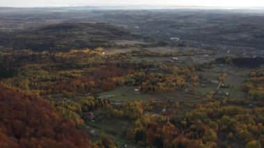 Kırsal alan manzarası, inanılmaz dağlar ve güzel renkli sonbahar ormanı, arka plandaki kırsal alan sonbahar manzarası. Sabahları ağaç tepelerinde uçan insansız hava aracı görüntüleri, doğa konsepti.