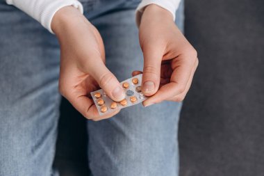 Doğum kontrol ve hamilelik konsepti. Genç bir kadının doğum kontrol haplarını açmasına, hormonal doğum kontrol haplarını tutmasına, korunmak için ilaç almasına, güvenli virüs seks hastalığına...