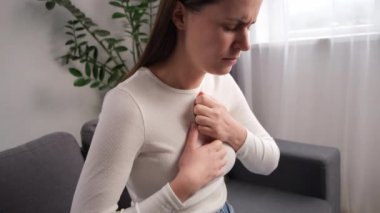 Kanepede oturan genç kadının yemek yedikten sonra sindirim probleminden kaynaklanan semptomları, yemek borusu, yemek borusu, mide ağrısı ve mide ekşimesi olan elleri var. Asit reflü hastalığı. Sağlık hizmetleri tıbbi konsepti