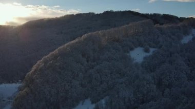Soğuk akşam manzarasında, kar ve karlı ağaçlarla kaplı kış ormanı dağlarında gün batımının muhteşem manzarası. Açık hava yaşam tarzı sağlıklı ve temiz hava için.