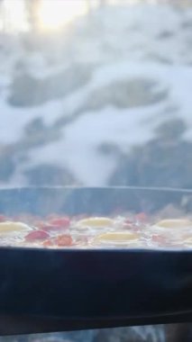 Shakshuka 'nın kış zamanı yemek pişirme ve yemek pişirme sürecinin dikey videosu. Kızartma tavasında çırpılmış yumurta, doğranmış dolma biber, domates ve soğan. Yemek pişirme konsepti