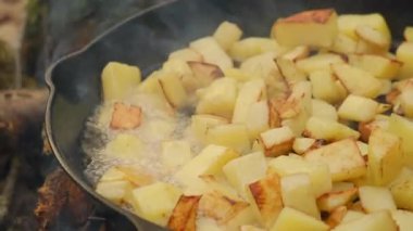 Baharın başında kızarmış patatesi siyah tavada pişirmeye devam et. Yürüyüşte dışarıda yemek pişirmek. Yiyecek konsepti