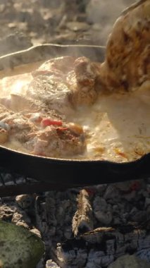 Bilinmeyen adamın tavuk göğsünü krema ve domatesle, taze kremayla, maydanozla, arka plandaki dağlarda bahar başında peynirle pişirdiği dikey görüntüler. Yemek pişirme konsepti