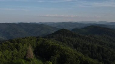 Yazın gökyüzüne karşı güzel dağların havadan görünüşü. Arka planda sıradağlar var. Temiz ve huzurlu bir manzara. Keşif ve seyahat konsepti