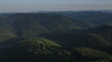 Güzel dağların ve yaz günbatımında mavi gökyüzünün hava aracı görüntüsü. Arka planda sıradağlar var. Temiz ve huzurlu bir manzara. Keşif ve seyahat konsepti
