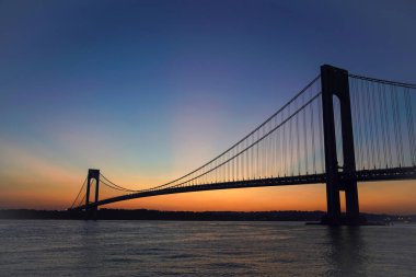 New York 'ta gün batımında Verrazano Köprüsü. Verrazano Köprüsü, Staten Island ve Brooklyn ilçelerini birbirine bağlayan çift katlı asma köprü.