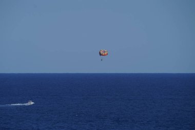 Parasailing in a blue sky in Palm Beach, Florida. Parasailing is a popular recreational activity among tourists in Florida