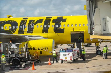 CANCUN, MEXICO - 18 Eylül 2021: Yer harekat ekibi Meksika 'daki Cancun Uluslararası Havalimanı pistindeki Spirit Airlines uçağına bagaj yükledi