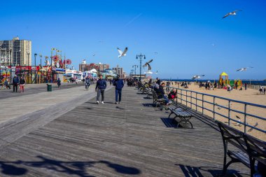 BrooKLYN, New York - 30 Mart 2021: Coney Island Beach ve Brooklyn, New York 'taki ünlü Coney Island Boardwalk. Riegelmann Boardwalk, 1923 'te inşa edildi, Güney Brooklyn' de 4.5 km boyunca uzanır.