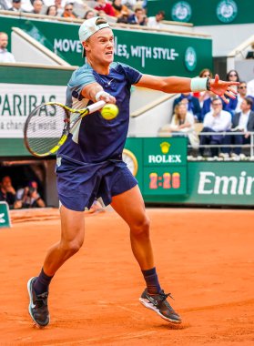 PARIS, FRANCE - MAY 30, 2022: Professional tennis player Holger Rune of Denmark in action during his round 4 match against Stefanos Tsitsipas of Greece at 2022 Roland Garros in Paris, France clipart