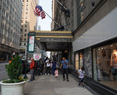 NEW YORK - 23 Mayıs 2023: New York 'un Midtown Manhattan' daki eski dört yıldızlı Roosevelt Oteli 'ndeki yeni göçmen karşılama merkezinin önündeki kimliği belirsiz göçmenler. Beklenen sığınmacı akınını karşılamak için açıldı.
