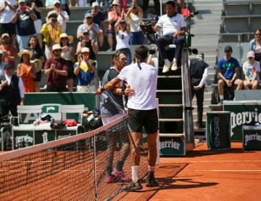 PARIS, FRANCE - 1 Haziran 2023: Arjantinli profesyonel tenisçi Tomas Martin Etcheverry ve Avustralyalı Alex de Minaur, Fransa 'nın başkenti Paris' te oynanan 2023 Roland Garros 'ta oynanan ikinci tur karşılaşmasının ardından ağdan sarıldı.