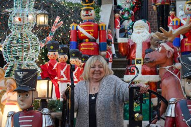 BrooKLYN, New York - 14 Aralık 2023: Lucy Spata, Brooklyn 'in Dyker Heights semtindeki Noel evi dekorasyonunun önünde. 1986 'da Dyker Heights' taki dekorasyon trendine öncülük etti.