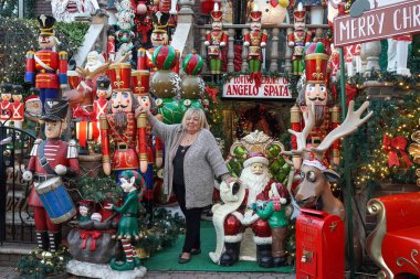 BrooKLYN, New York - 14 Aralık 2023: Lucy Spata, Brooklyn 'in Dyker Heights semtindeki Noel evi dekorasyonunun önünde. 1986 'da Dyker Heights' taki dekorasyon trendine öncülük etti.